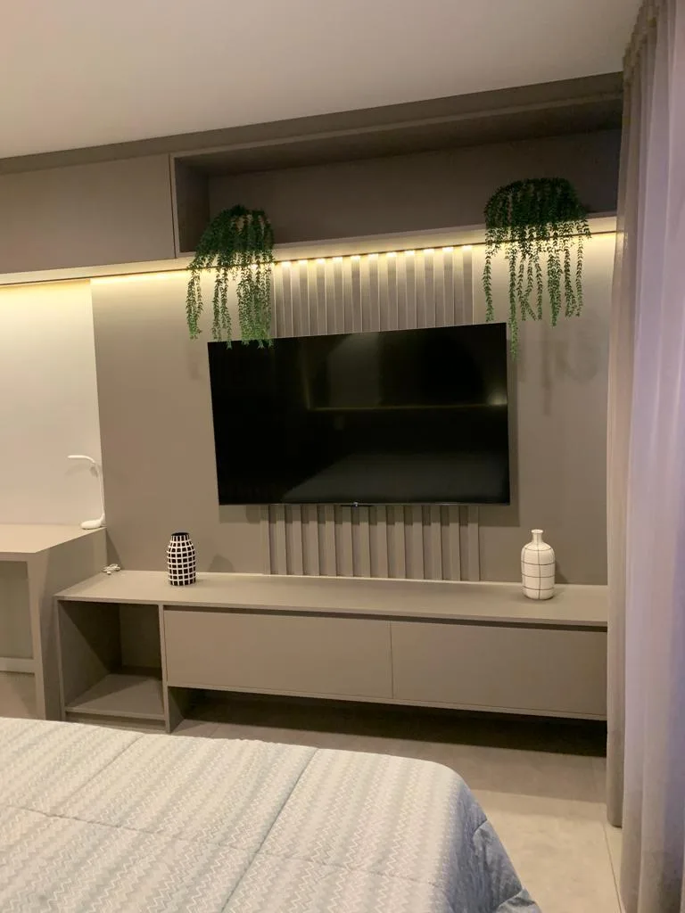 Painel de TV ripado com nichos no dormitório