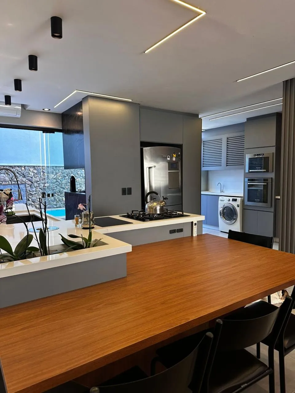 Cozinha gourmet planejada com ilha e vista para a piscina