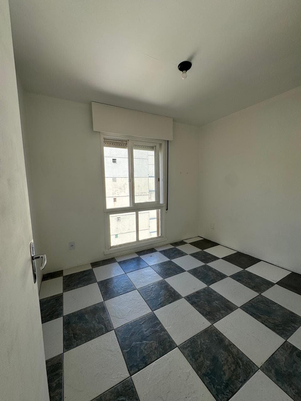 Sala antes da reforma, com piso xadrez antigo